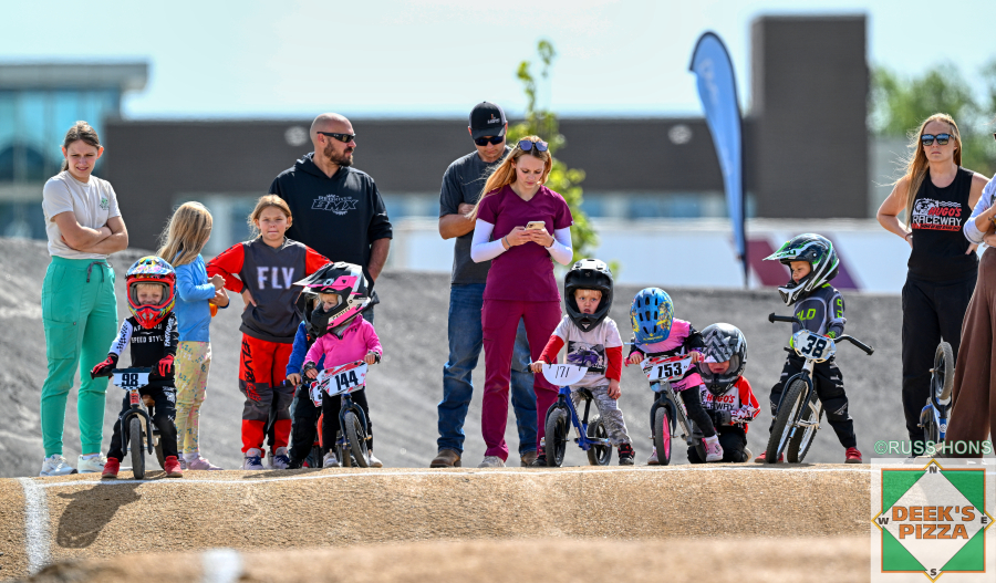 Balance bike riders lined up with families at Hugo's Raceway