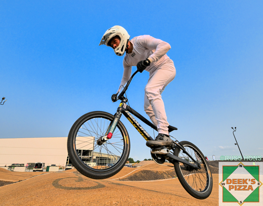 BMX rider jumping over track rollers