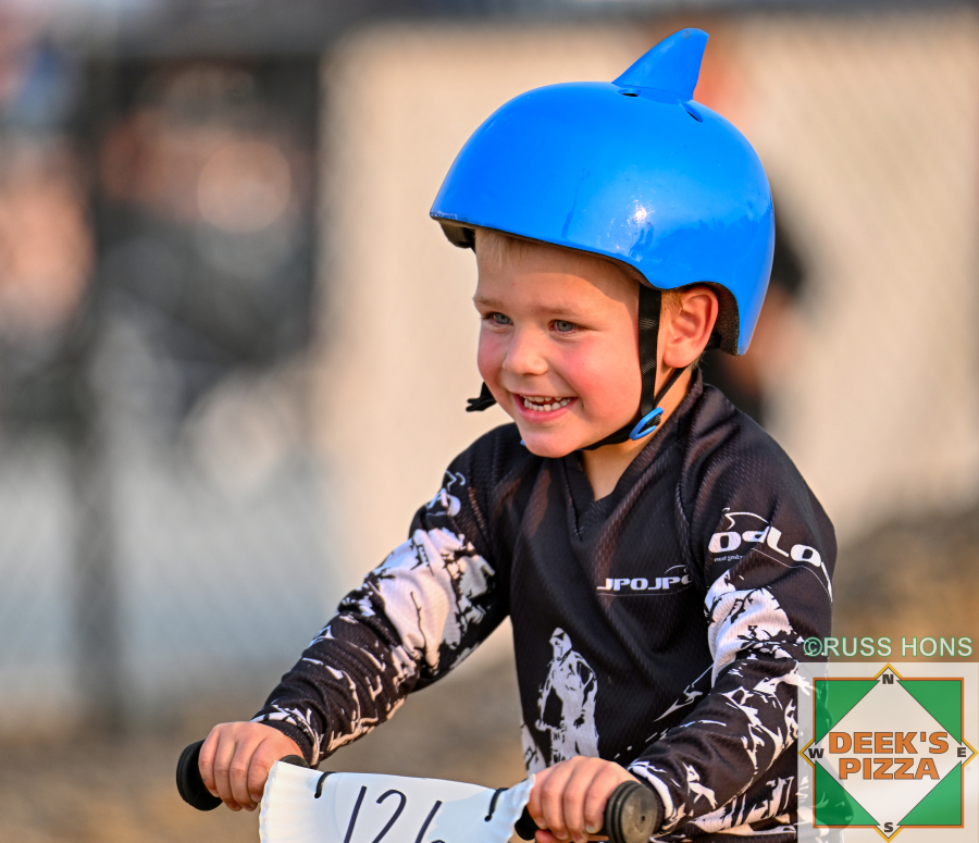 Young balance bike rider smiling at Hugo's Raceway