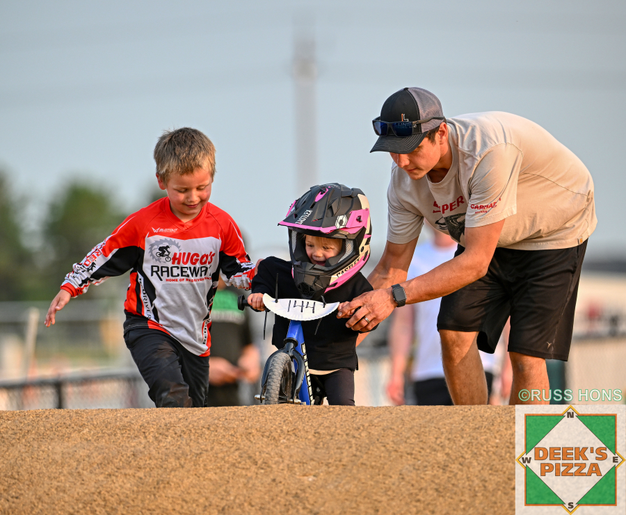 Family helping a balance bike rider at Hugo's Raceway